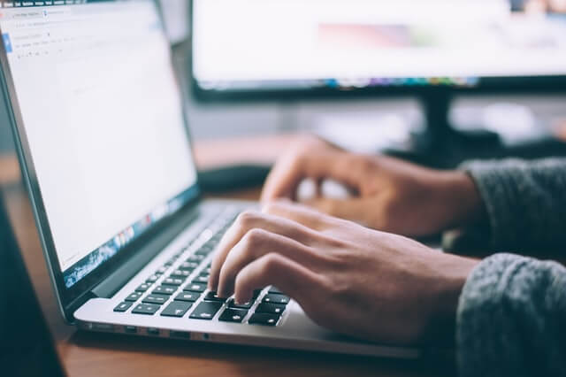 a person typing on their notebook